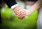Young married couple holding hands, ceremony wedding day